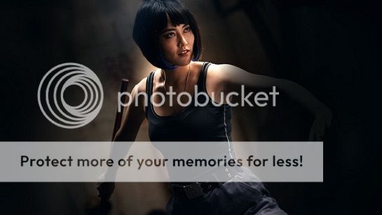 Mako in cargo pants and a black tank top with blue streaks in her black hair, standing in a fighting stance and smirking